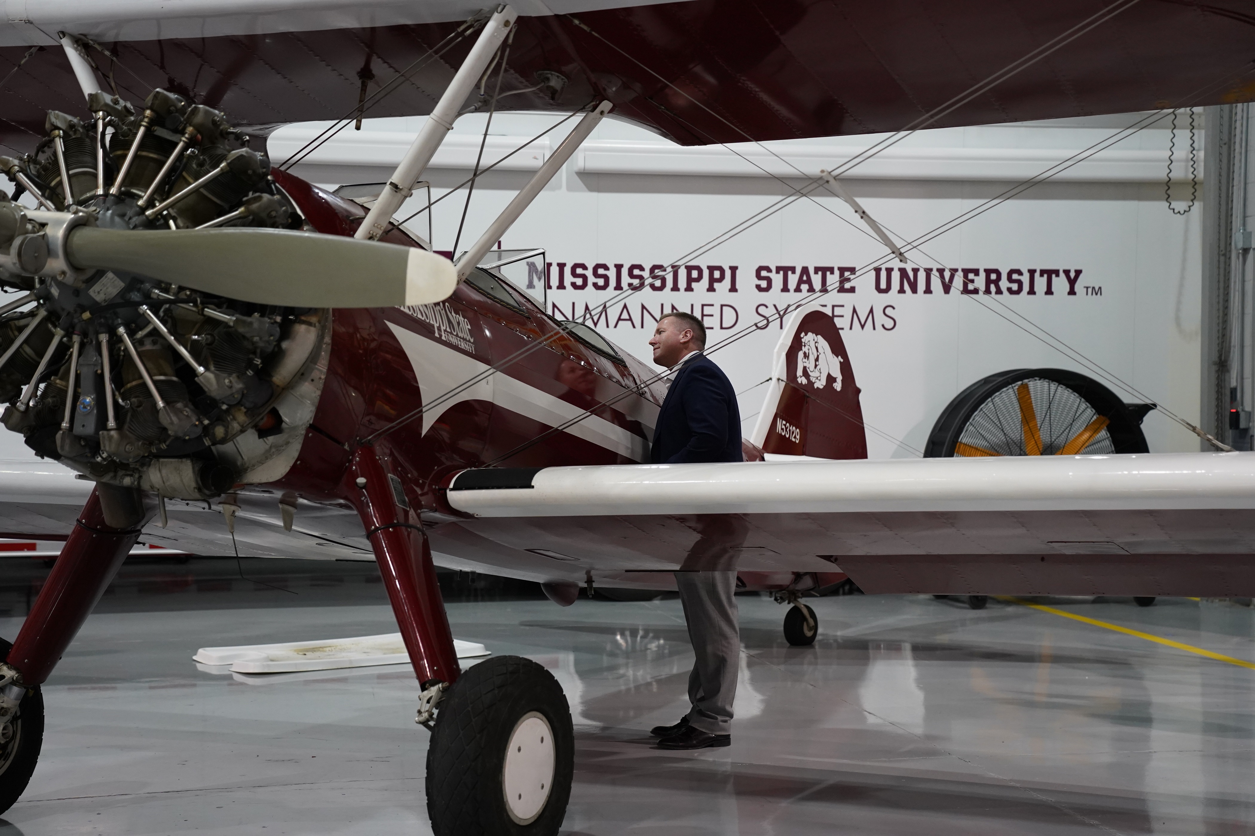 A man looks inside the cockpit of a Raspet Flight Lab Stearman airplane.
