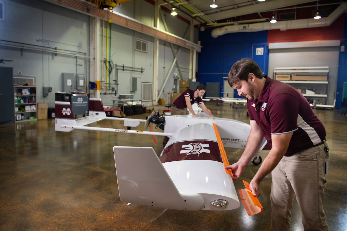 Two engineers apply 3D printed ice shapes to the leading edges of unmanned aircraft system wings. 